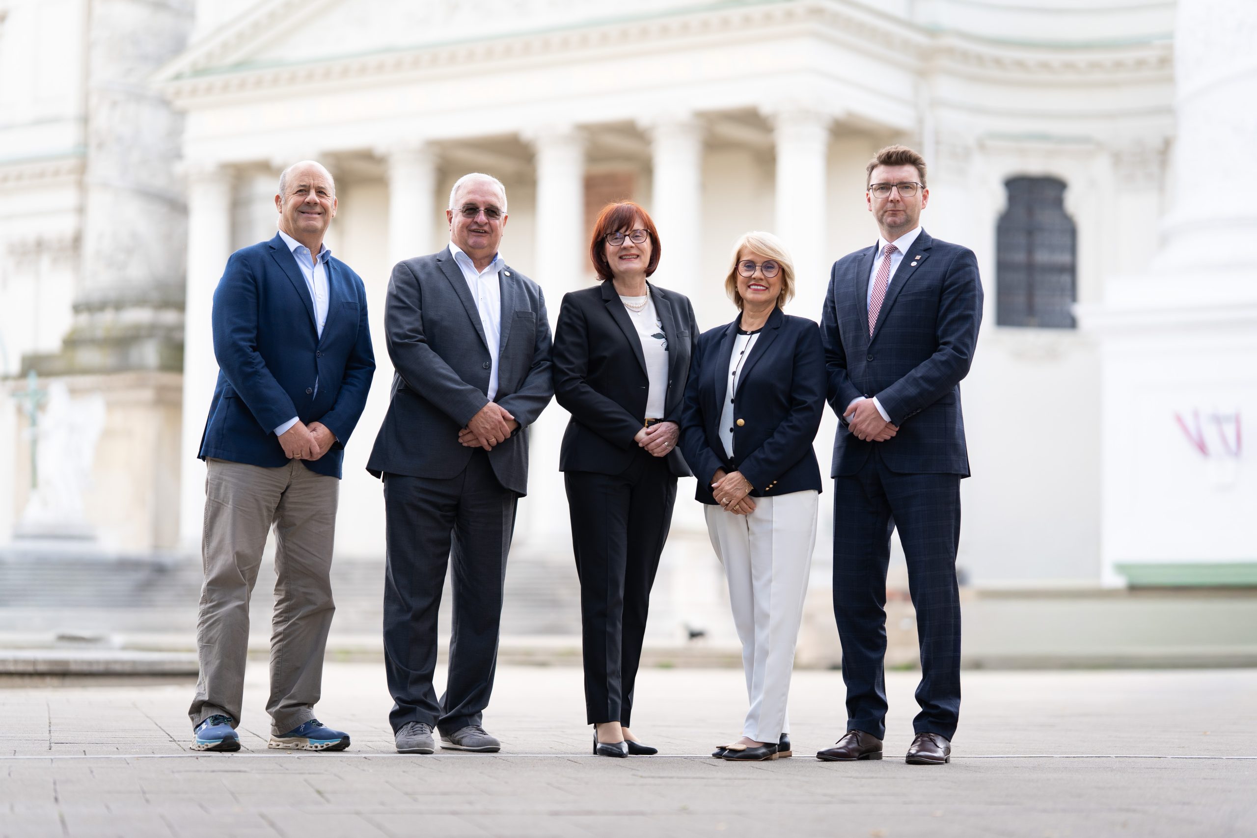Photo of people posing in front of a building
